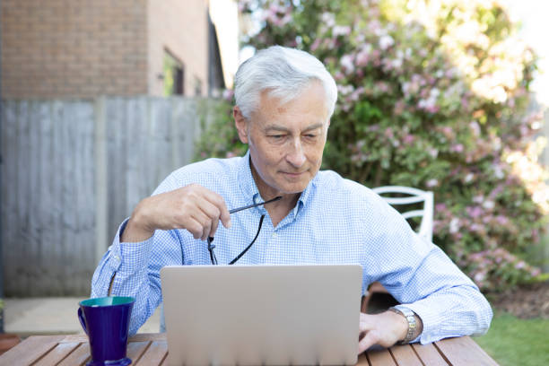 istock Mature man using a laptop in the garden 1496200854