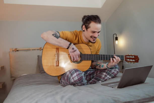 istock A young man is learning to play guitar in an online class 1496200964