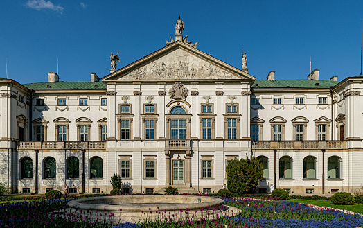 Warsaw, Poland - May 01, 2022: Beautiful  green spring park in the Krasinski Palace and garden in Warsaw. Palace Rzeczypospolitej at in spring
