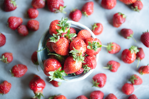 composition of fresh berries and green leaves isolated on white background, top view