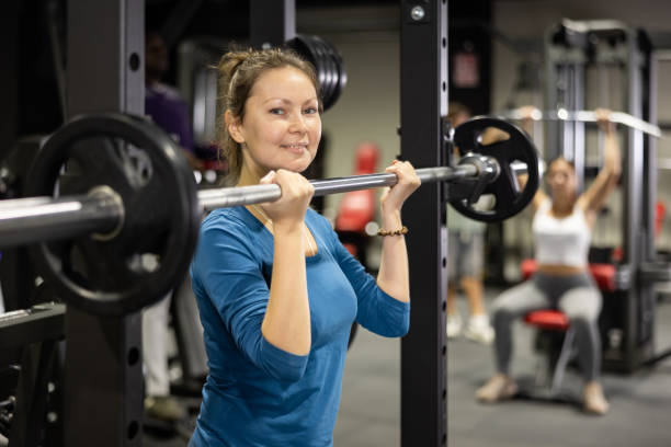istock Sportswoman doing exercises with a barbell in gym 1496215300