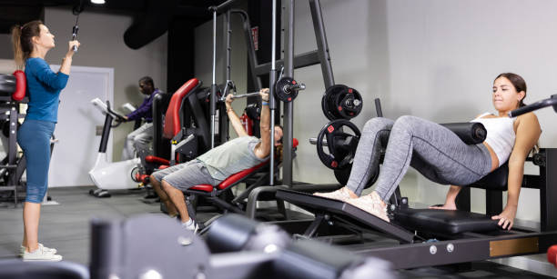 istock Men and women training on machines in gym 1496215463
