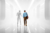Young businessman with Ai avatar walking in futuristic corridor