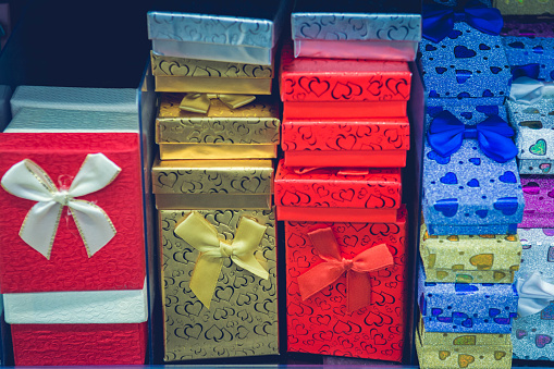 Lots of presents for kids and loved one. Partner gifts. Boyfriend and girlfriend gifts. Happy family time. Surprise someone. Red, blue, gold happy box. Wrapped gifts and wrapping materials. Toned photography
