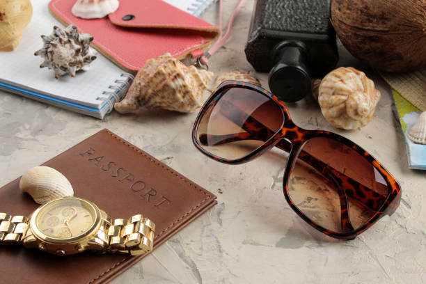 Travel concept passport, map, camera and sunglasses on a light concrete background.