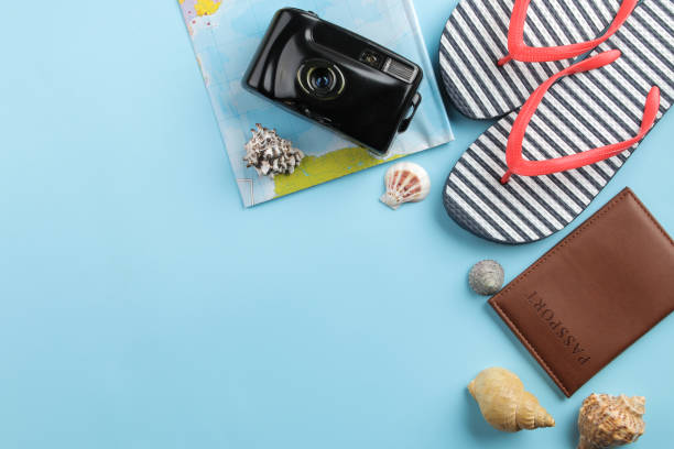 istock Travel concept. Passport, camera, flip flops, map and glasses on a bright blue background. top view. space for text 1496232856