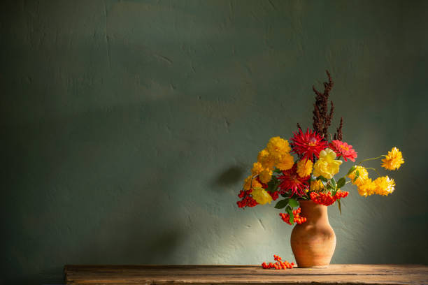 istock red and yellow flowers on jug in sunlight on background dark wall 1496233150