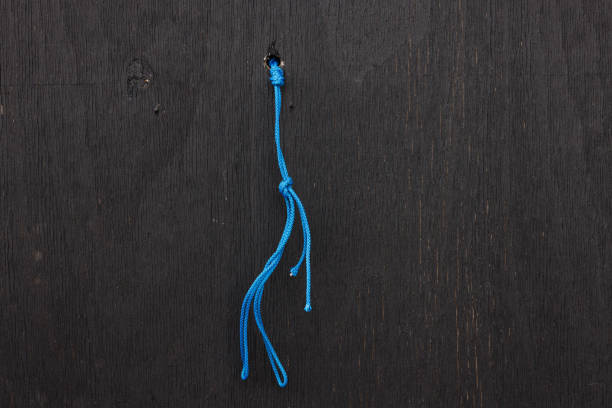 Blue rope tied to a plain black wooden wall