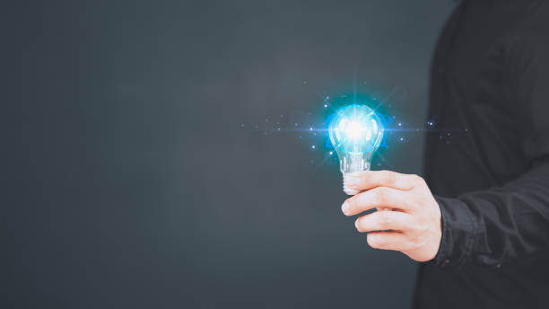 istock Innovation and inspiration idea. Man hand holding illuminated light bulb, creative with glowing light bulb. Inspiration concept of learning, new knowledge and sustainable business development. 1496260097