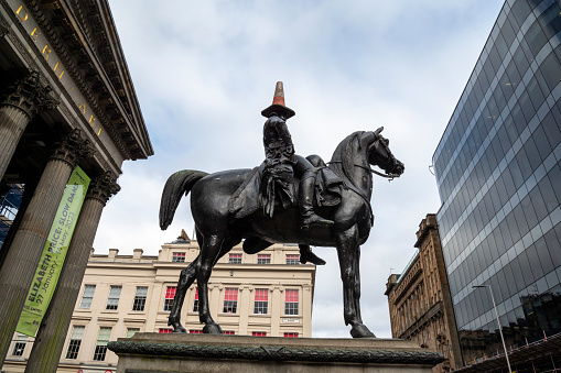 Glasgow, Scotland_February 28,2023.\nStatue of the Duke of Wellington in central Glasgow. Some years back students placed a road stop cone on his head to show their dislike of the English and the cone has remained ever since, becoming a tourist attraction.