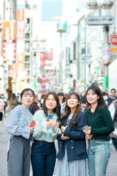 istock Young women using smartphones in the city 1496266530