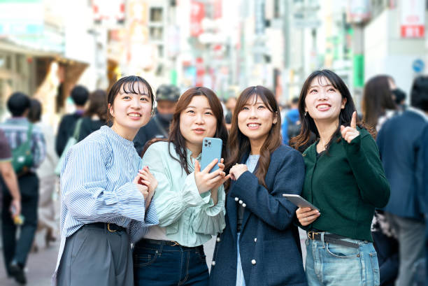 istock Young women using smartphones in the city 1496266565