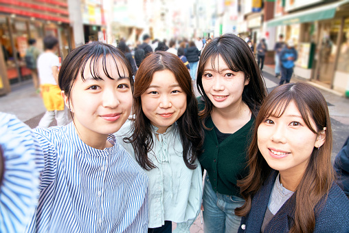 Four women taking selfies in the city