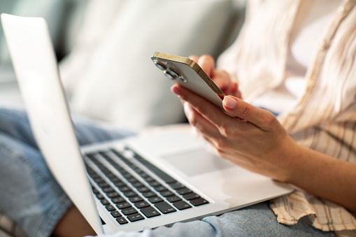 Close up of a young woman using a smart phone at home