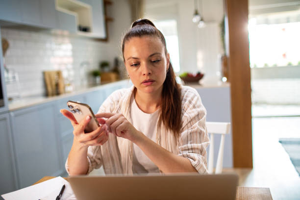 istock Young woman going over her finances at home while using her laptop 1496267809
