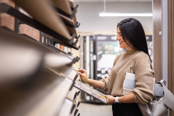 istock Happy brunette female interior designer choosing flooring tile color texture samples at store shop 1496269048
