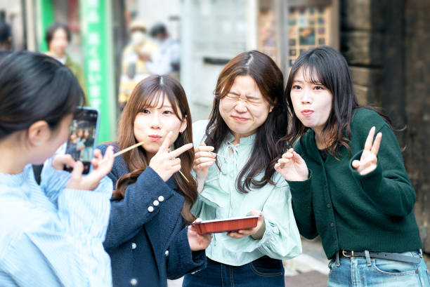istock Four women eating takoyaki while walking 1496269335