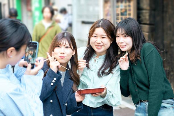 istock Four women eating takoyaki while walking 1496269855
