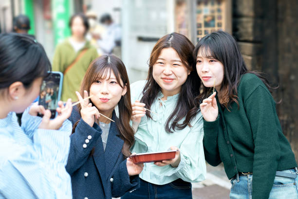 istock Four women eating takoyaki while walking 1496269879