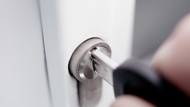 The key to the door is inserted into the lock and turned close-up