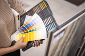 Female interior designer hands choosing color epoxy grout for ceramic tiles samples guide closeup