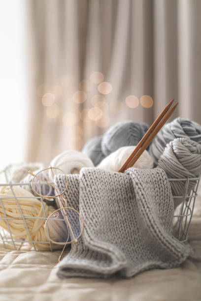 ambiance chaleureuse et chaleureuse. tricot de loisir féminin. fil de couleurs neutres dans un panier noir en fer noir. - knitting vertical striped textile photos et images de collection