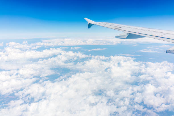 istock View from the airplane window at a beautiful cloudy sky and the airplane wing 1496276131
