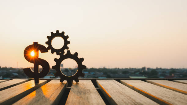 istock Dollar model and gear model with evening sky. Concepts for methods, systems of raising or lowering Fed interest rates to correct inflation concepts. 1496277394