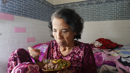 grandmother who is pensive and daydreaming while eating. old woman with cataract and delusional mental disorder