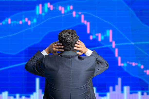 stress-börsenhändler schaut auf den bildschirm zeigt die candlestick-chart-grafik, die nach unten geht, finanzmarkt-crash. - gambling loss asian ethnicity depression stock-fotos und bilder