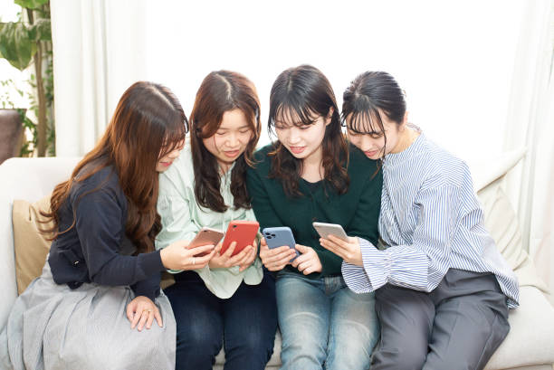 istock Four women talking while looking at a smartphone 1496290877