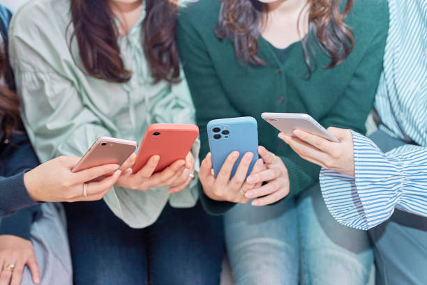 istock Four women talking while looking at a smartphone 1496291019