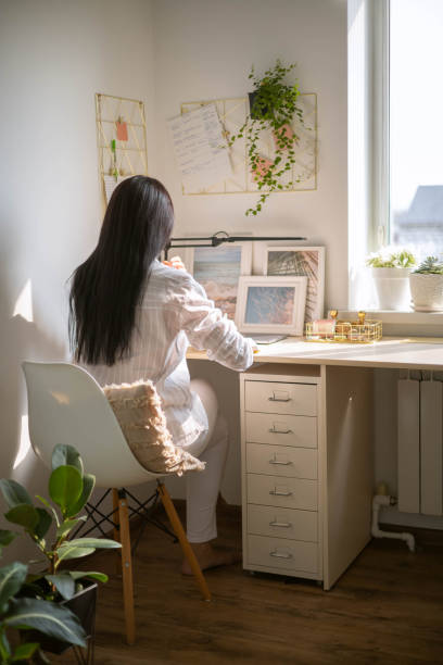 istock Modern brunette business woman writing diary notebook paper notes with pen on comfortable desk 1496292554