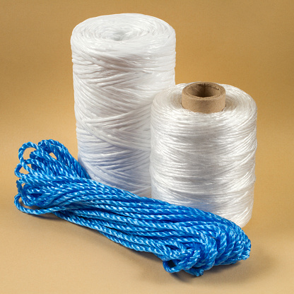 Synthetic rope for domestic use. Various coils of rope. Rope on a yellow background.