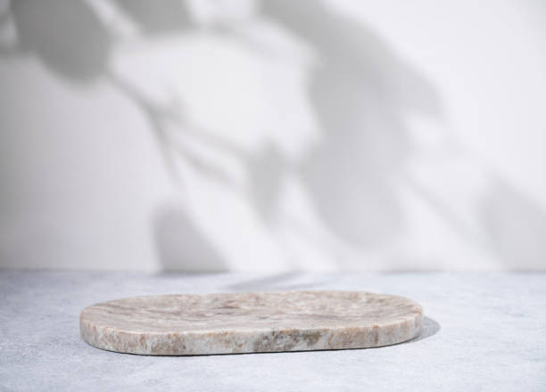 istock Marble oval board with shadow of plants on a light blue background for product demonstration. Trendy neutral aesthetic layout template for beauty and cosmetics scene 1496294283