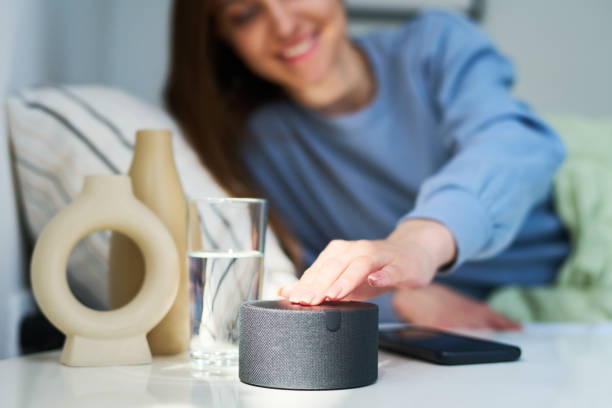 istock Woman turning on alarm clock on smart speaker 1496294884