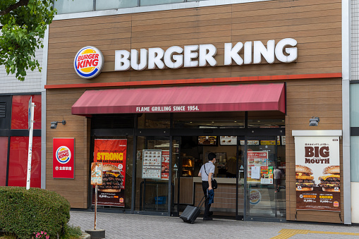 Kyoto, Japan - April 17, 2019: People walking near Nijo Station in morning by Mos Burger fast food restaurant wide angle view