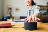 Woman using smart speaker at home