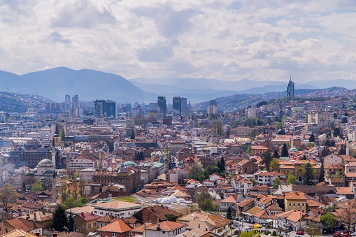 Sarajevo, Bosnia and Herzegovina – May 08, 2023: An aerial view of a bustling cityscape featuring a prominent clock tower atop a hill, Sarajevo