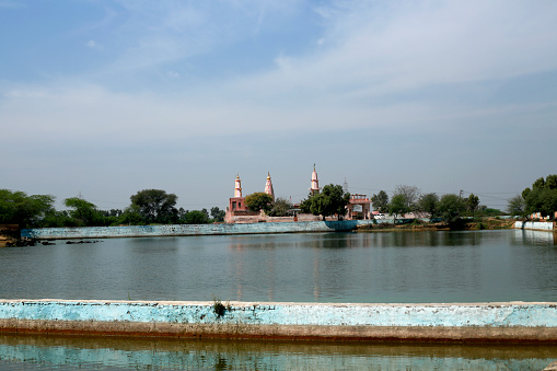 Hindu Temple near sacred pond landscape during summer season.