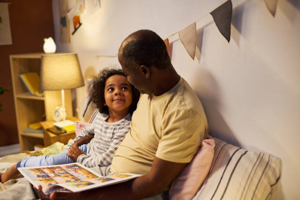 istock Dad reading tale to his child before sleep 1496297831