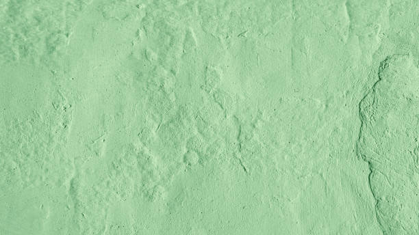 istock Stucco plaster wall background texture of light green painted cement, concrete wall 1496299622