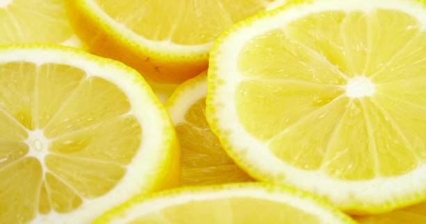 istock Close up fresh lemon slices pattern background. Lemon cut in a half above. Bright juicy sliced lemon slices. Texture background, pattern 1496301900