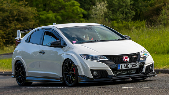 Stony Stratford,UK - June 4th 2023:  2015 white HONDA CIVIC GT classic car travelling on an English country road.