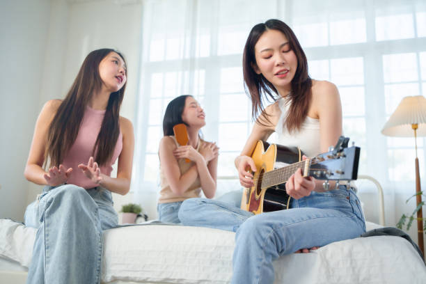 istock Asian women playing acoustic guitar and singing 1496303614