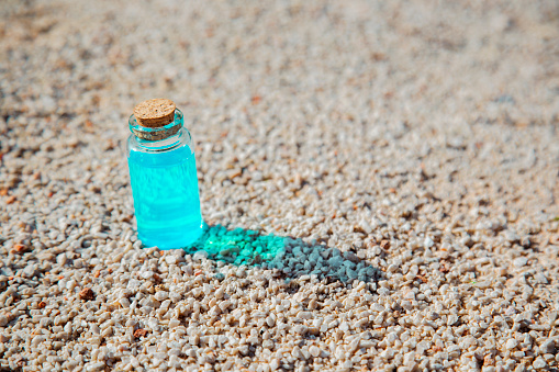 A bottle of essential oil soft blur color on sand. The concept of aromatherapy, dry skin, beauty product, relax and spa, copy space