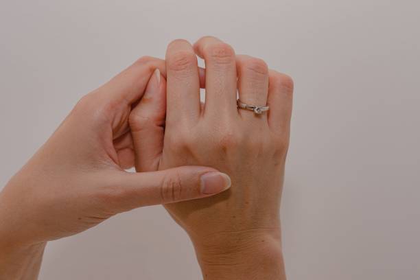 istock Woman's hands displaying a sparkling diamond engagement ring on a white background. 1496305000