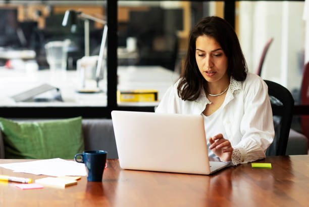 istock Young smiling woman working on laptop. 1496305378
