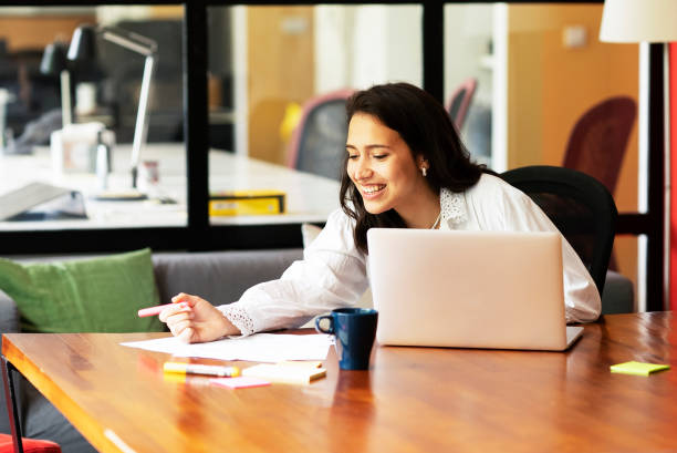 istock Young smiling woman working on laptop. 1496305379