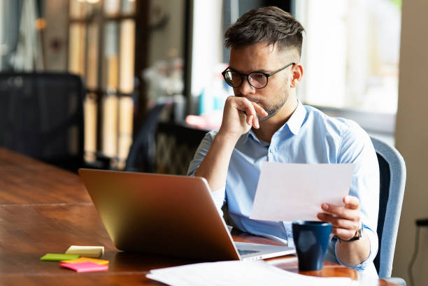 istock Young smiling man working on the project in office. 1496305852